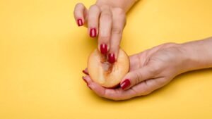 a person holding a peach fruit